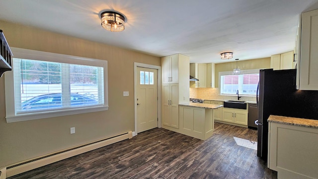 kitchen with light stone counters, pendant lighting, dark wood finished floors, tasteful backsplash, and baseboard heating