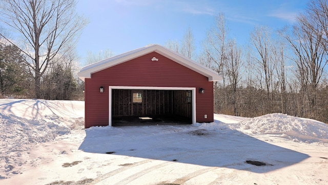 snow covered garage featuring a detached garage