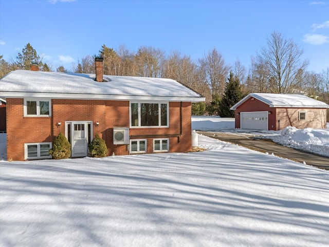 view of front of house with an outbuilding, brick siding, a chimney, and a garage