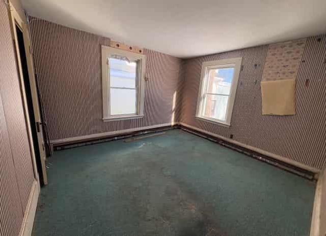 unfurnished room with dark colored carpet