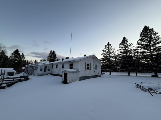 view of snow covered back of property