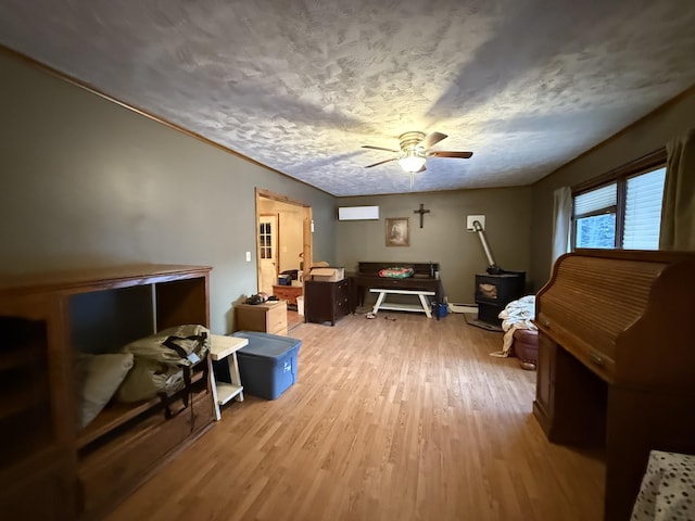 miscellaneous room with ceiling fan, a wall mounted air conditioner, light hardwood / wood-style floors, a textured ceiling, and a baseboard radiator