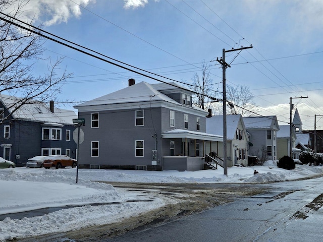 snow covered property with a porch