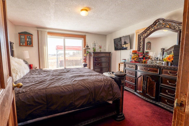 bedroom featuring a textured ceiling, dark carpet, and access to exterior