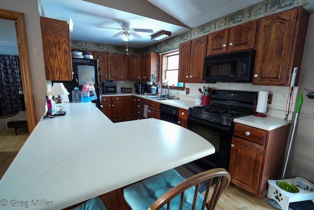 kitchen featuring vaulted ceiling, sink, decorative backsplash, ceiling fan, and black appliances