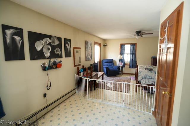 living room featuring a baseboard heating unit and ceiling fan