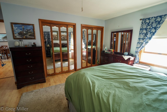 bedroom featuring multiple closets and light wood-type flooring