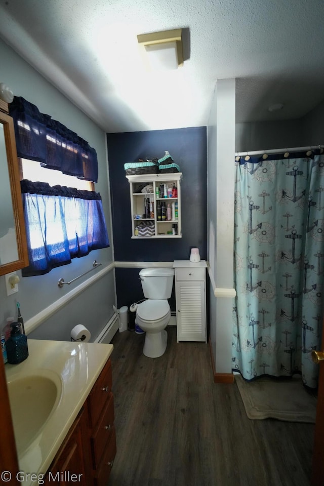 bathroom featuring toilet, wood-type flooring, a textured ceiling, baseboard heating, and vanity