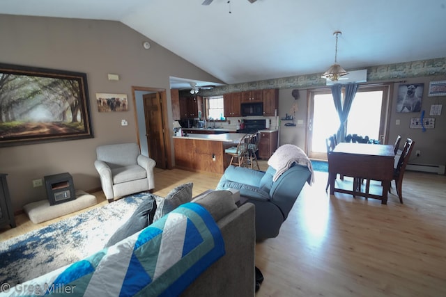 living room featuring light wood-type flooring, a wealth of natural light, ceiling fan, and vaulted ceiling