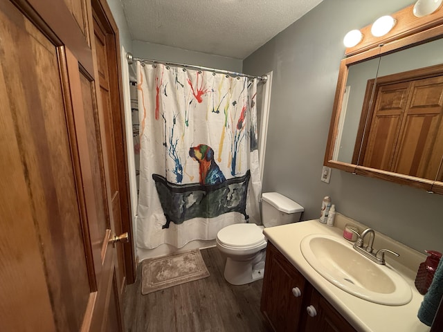 bathroom featuring vanity, wood-type flooring, a textured ceiling, a shower with curtain, and toilet