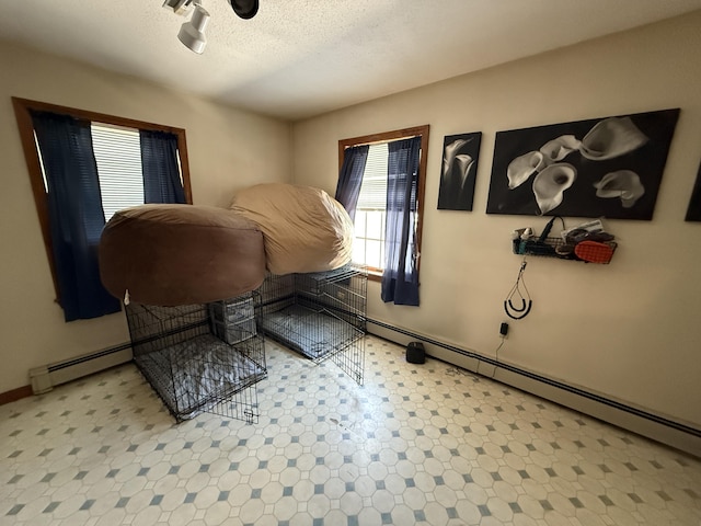 interior space with a baseboard heating unit and a textured ceiling