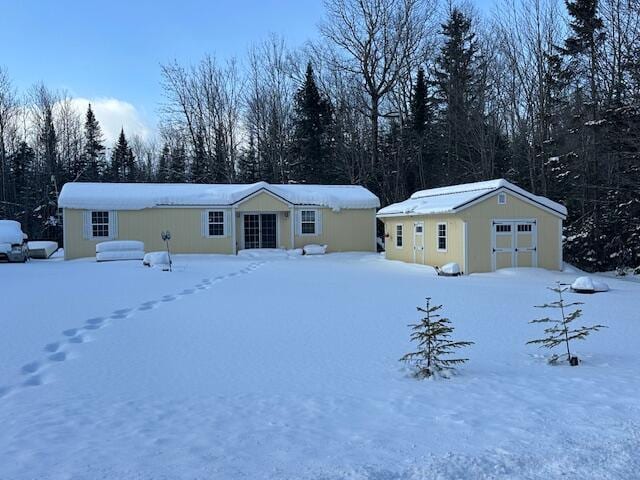 view of front of home featuring a garage and an outbuilding