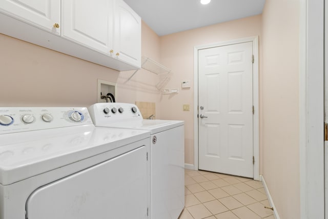 laundry area featuring light tile patterned floors, independent washer and dryer, cabinet space, and baseboards