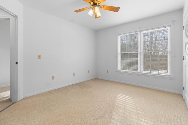 carpeted spare room with a ceiling fan, a healthy amount of sunlight, and baseboards