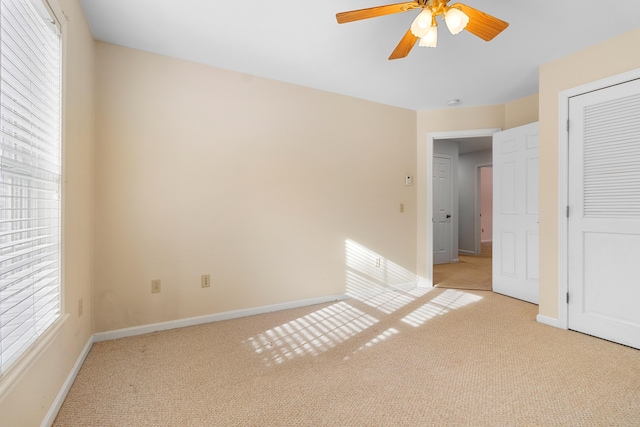 unfurnished bedroom featuring light carpet, ceiling fan, and baseboards