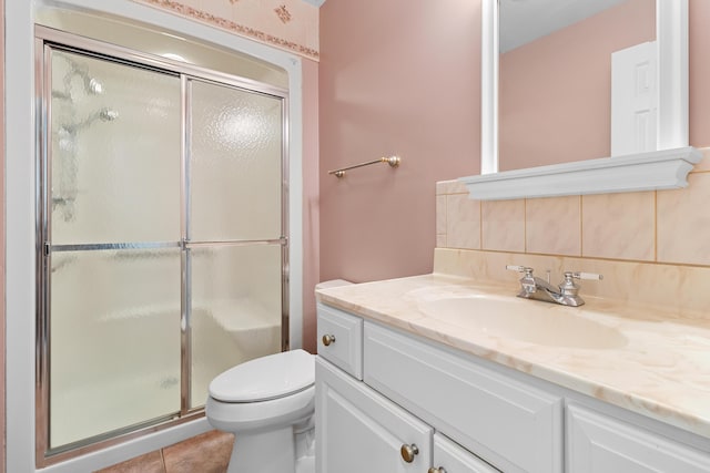 full bath with a stall shower, backsplash, vanity, and toilet