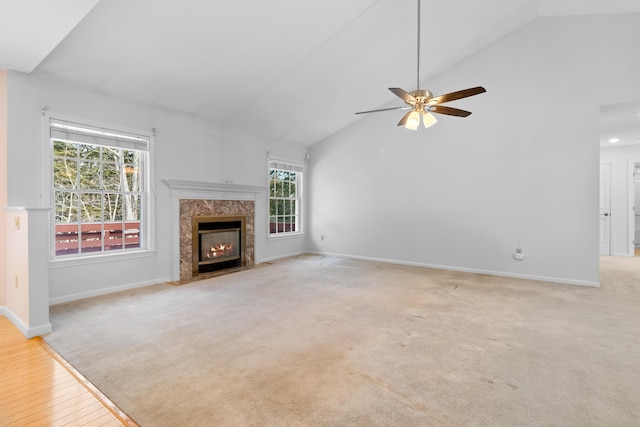 unfurnished living room featuring high vaulted ceiling, a fireplace, and baseboards