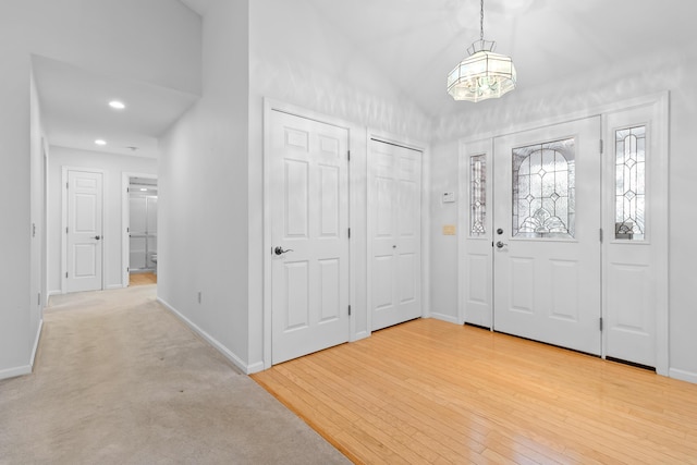 entryway featuring a chandelier, recessed lighting, baseboards, and wood finished floors