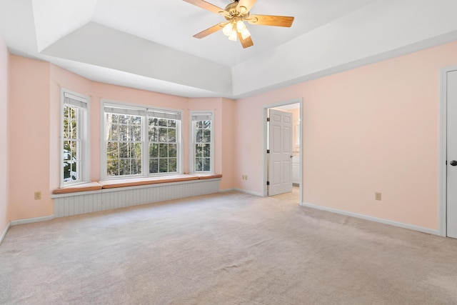 spare room with light carpet, baseboards, and a tray ceiling