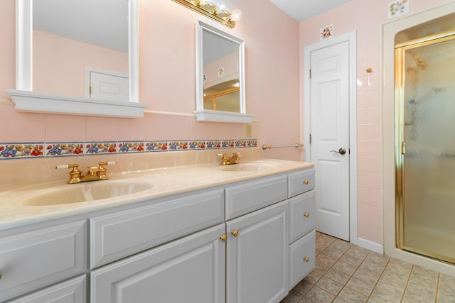 full bath featuring a stall shower, a sink, and tile patterned floors