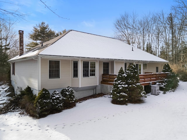 view of front of house with a porch, cooling unit, and a chimney