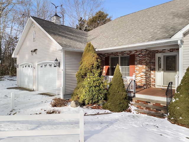 view of front facade featuring covered porch, roof with shingles, a chimney, and brick siding