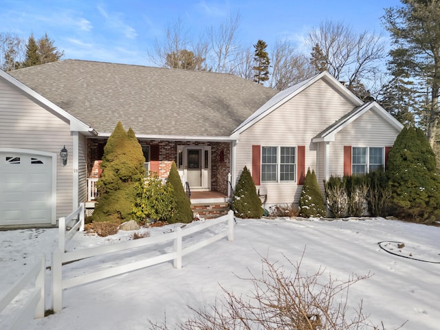 ranch-style house featuring an attached garage, brick siding, and roof with shingles