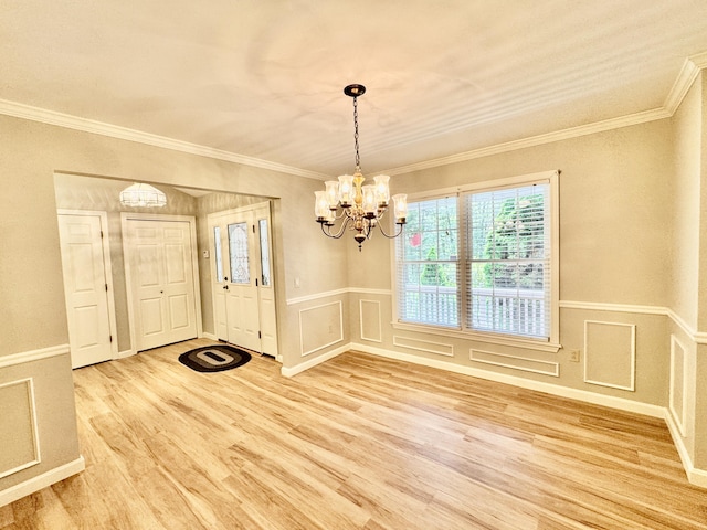 18 Patricia Ln, Saint George, ME 04859 - entryway with a chandelier, light wood finished floors, crown molding, a wainscoted wall, and a decorative wall