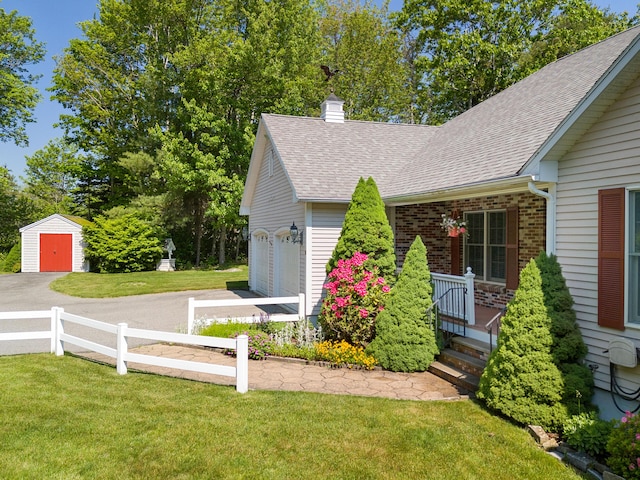 18 Patricia Ln, Saint George, ME 04859 - view of property exterior with roof with shingles, a chimney, a storage unit, and an attached garage