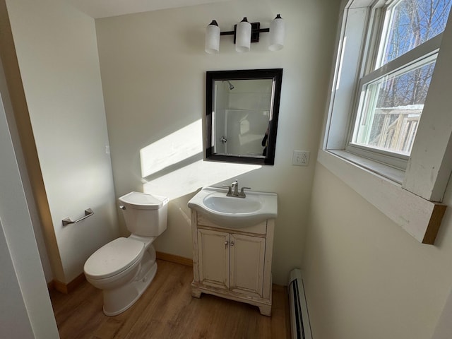 bathroom featuring hardwood / wood-style flooring, a baseboard radiator, vanity, and toilet