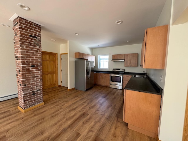 kitchen with sink, a baseboard radiator, stainless steel appliances, and dark hardwood / wood-style floors