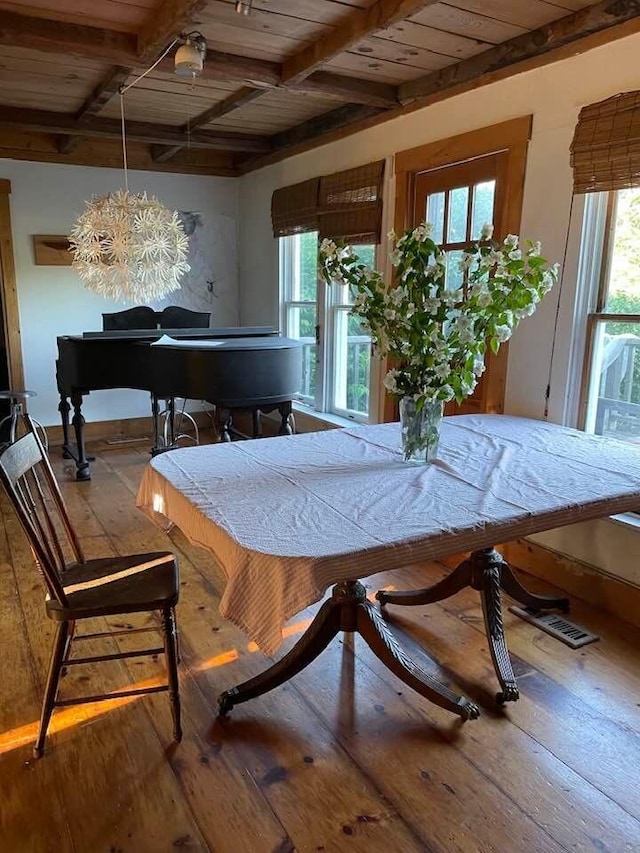 dining area with a healthy amount of sunlight, hardwood / wood-style flooring, and beam ceiling