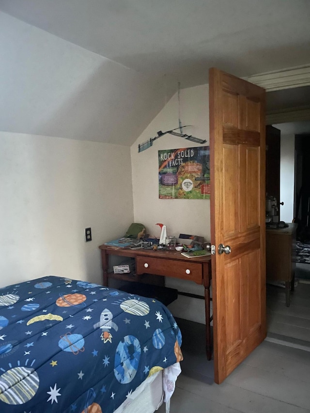 bedroom with lofted ceiling and wood finished floors