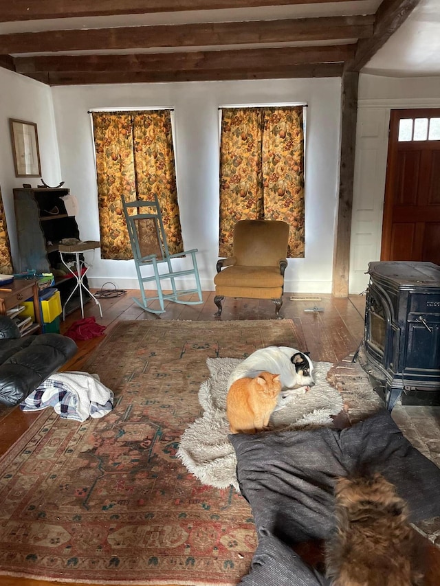 living room with a wood stove and beam ceiling