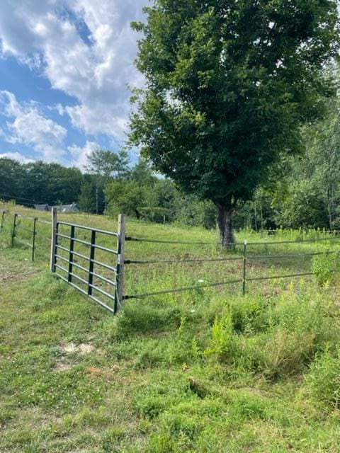 view of gate featuring a rural view and fence