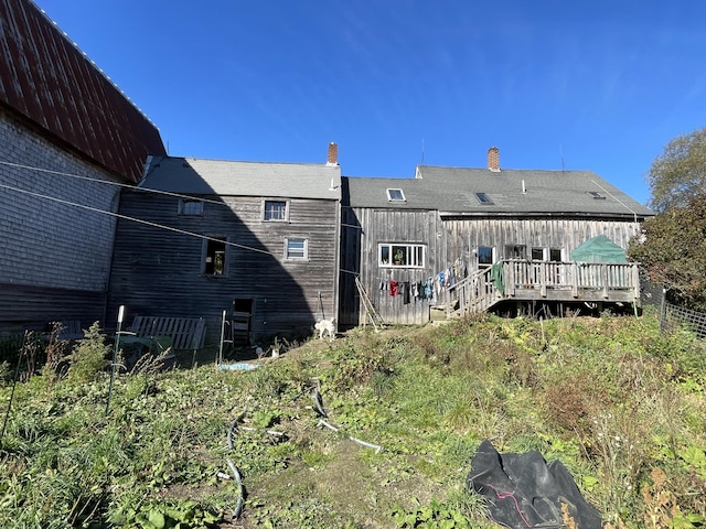 back of house with fence and a deck