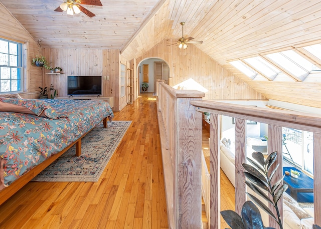 bedroom featuring wooden ceiling, vaulted ceiling with skylight, and light wood-type flooring