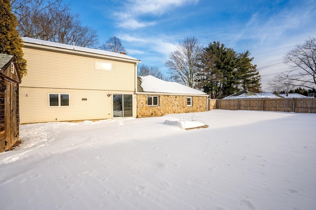 view of snow covered rear of property