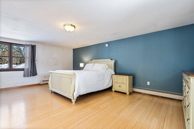 bedroom with a baseboard radiator and light hardwood / wood-style flooring