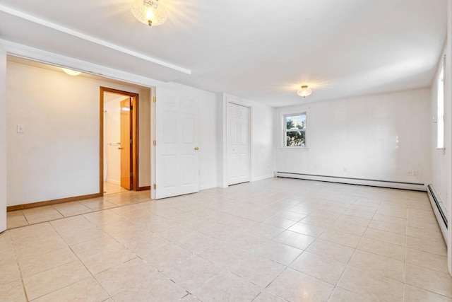 tiled spare room featuring a baseboard radiator