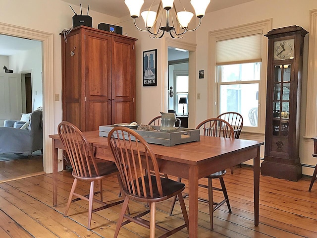 dining room with a notable chandelier and light wood-type flooring