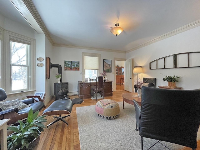 living room with ornamental molding, a healthy amount of sunlight, hardwood / wood-style floors, and a wood stove