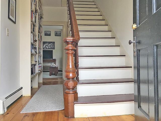 staircase featuring hardwood / wood-style flooring and a baseboard radiator