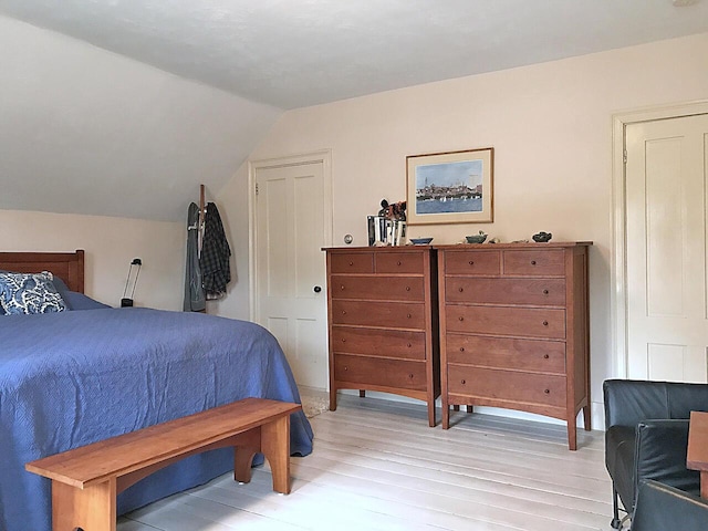 bedroom with vaulted ceiling and light wood-type flooring