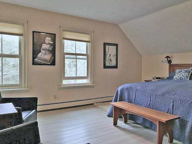 bedroom with multiple windows, vaulted ceiling, light hardwood / wood-style flooring, and baseboard heating