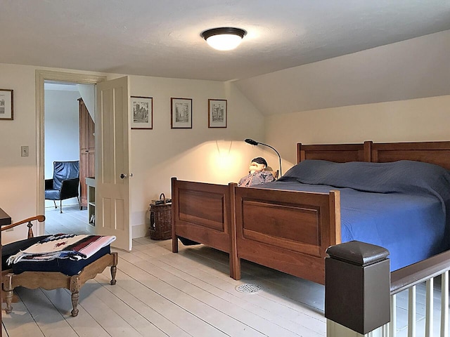 bedroom with light hardwood / wood-style flooring and vaulted ceiling