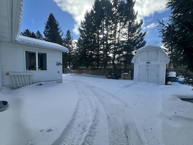 snowy yard with a shed