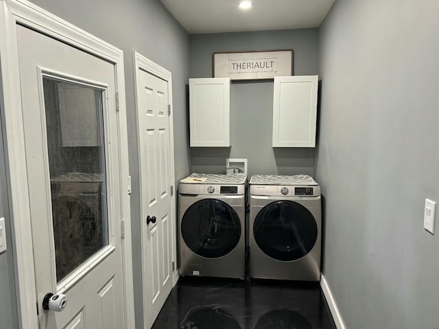 washroom featuring washer and clothes dryer and cabinets