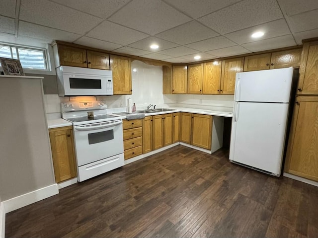 kitchen featuring white appliances, dark hardwood / wood-style floors, a paneled ceiling, and sink