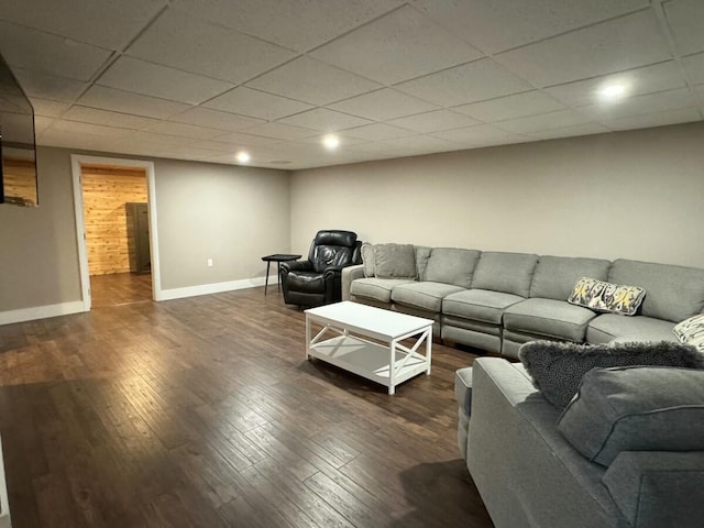 living room featuring a drop ceiling and dark hardwood / wood-style floors